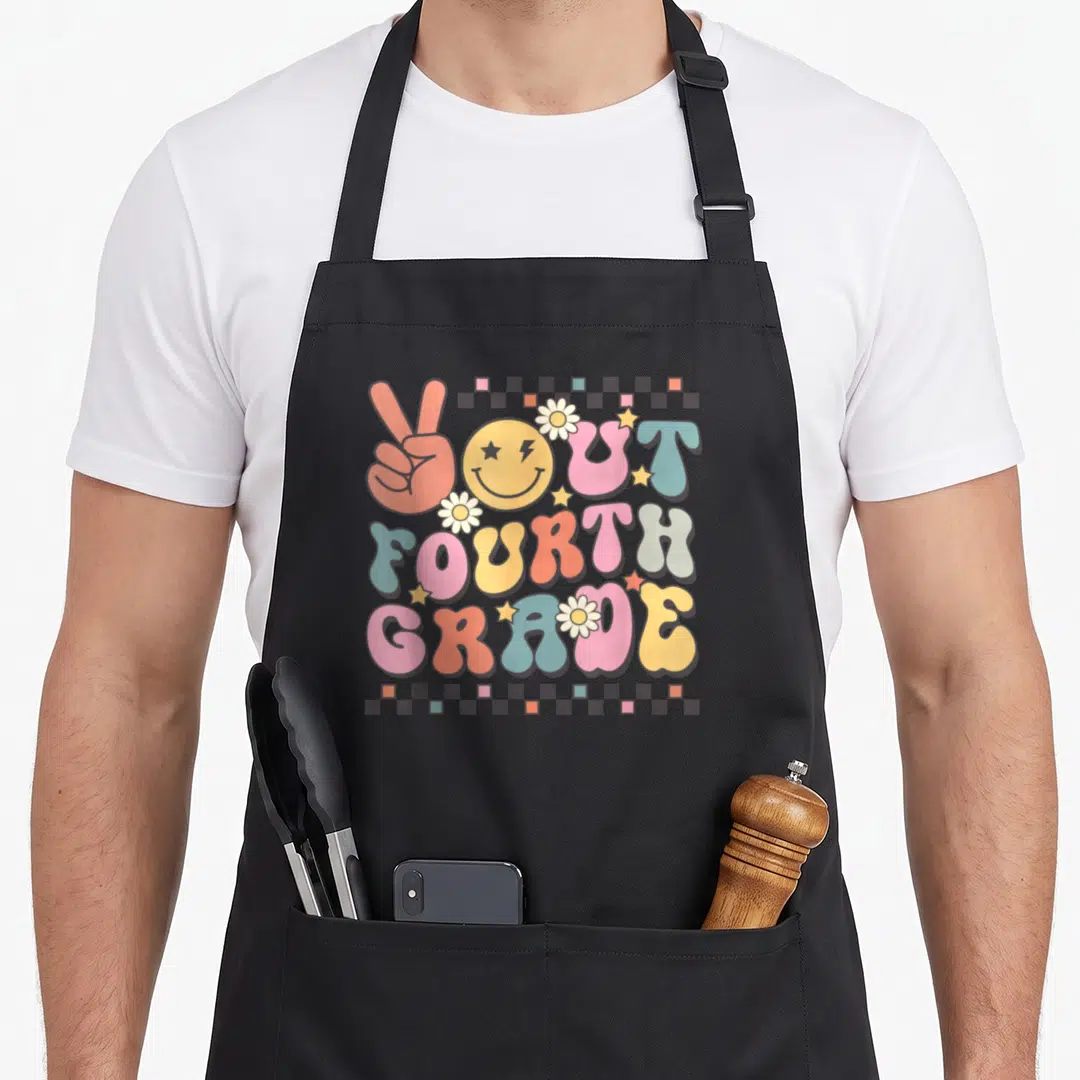 4th face apron - Retro bubble text You're Fourth Grade with peace sign, smiley face, flowers, and checkerboard border — shown on a black cotton canvas apron against a white background