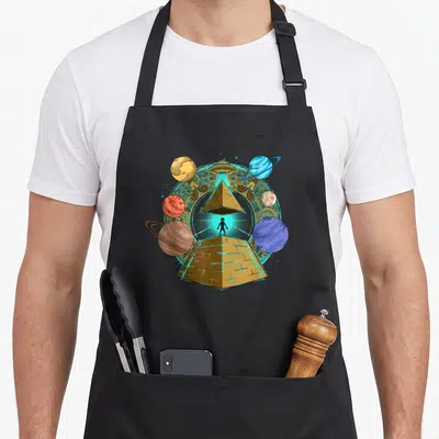 Pyramid science apron - Gold pyramid with black alien silhouette, hovering UFO, and surrounding planets inside a carved — shown on a black cotton canvas apron against a white background
