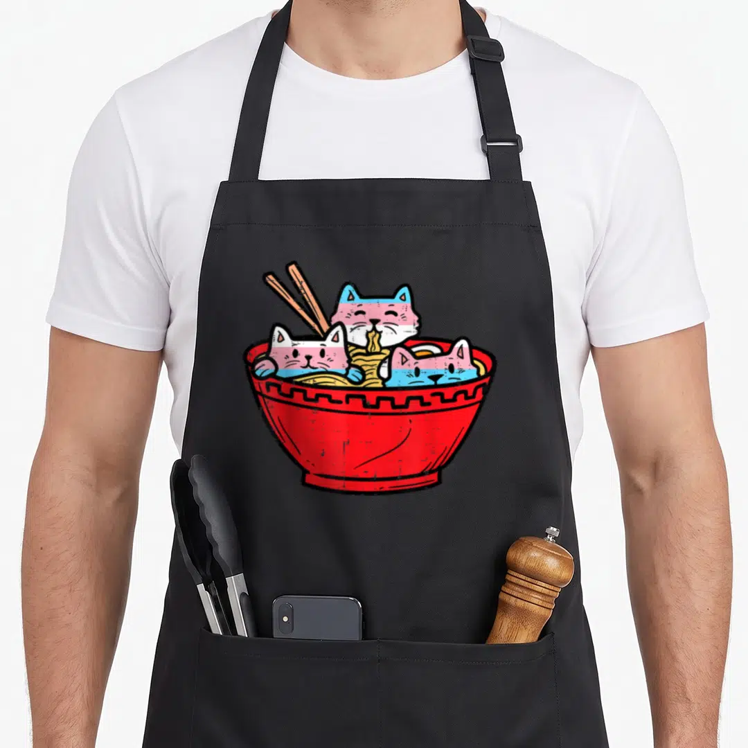 Tran cat apron - Three cats with blue pink and white stripes sitting in a red noodle bowl with chopsticks — shown on a black cotton canvas apron against a white background