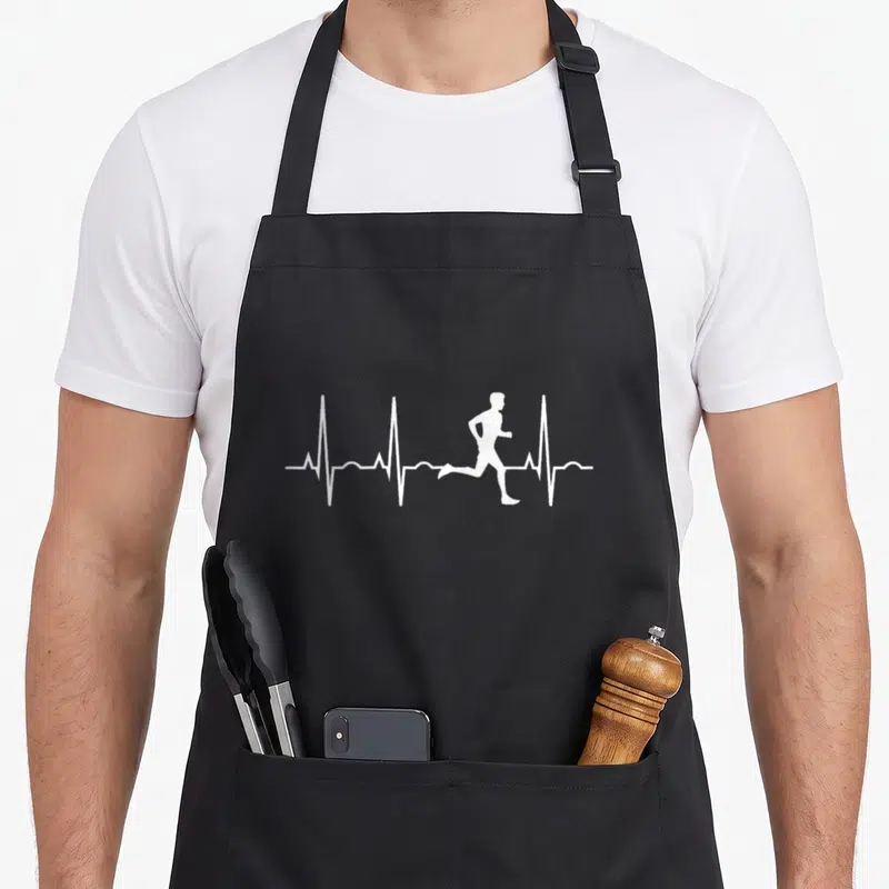 Runner marathon apron - White runner silhouette integrated into a horizontal heartbeat line on dark fabric — shown on a black cotton canvas apron against a white background