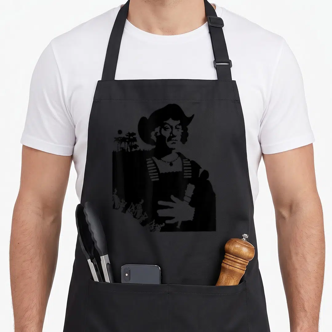 Explorer columbus apron - Black silhouette of a man with ships and palm trees in line art style — shown on a black cotton canvas apron against a white background