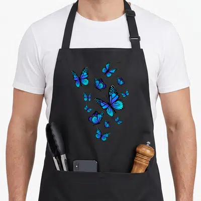 Blue butterfly apron - 11 realistic blue butterflies with black outlines and white wing dots scattered across a dark — shown on a black cotton canvas apron against a white background