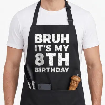 Cute bruh birthday apron - White distressed text stacked 4 lines reading BRUH IT'S MY 8TH BIRTHDAY — shown on a black cotton canvas apron against a white background