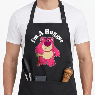Hugger dog breed aprons - Pink bear holding red bat with arched I'm A Hugger text — shown on a black cotton canvas apron against a white background