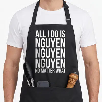 Nguyen pride apron - White stacked text reading ALL I DO IS NGUYEN NO MATTER WHAT — shown on a black cotton canvas apron against a white background