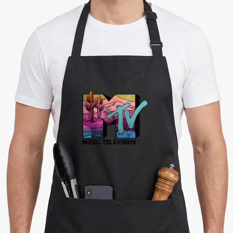 Mtv colorful apron - Retro MTV logo with cactus desert scene in pink blue purple and black text below — shown on a black cotton canvas apron against a white background