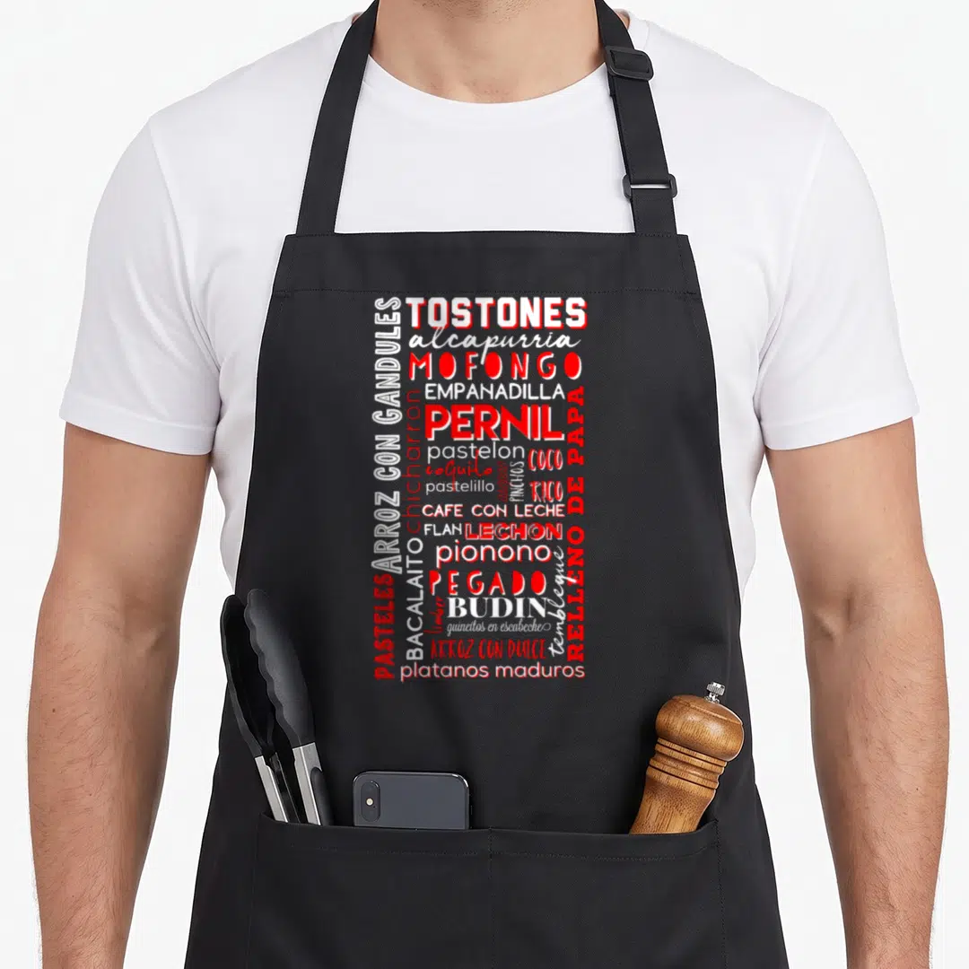 Puerto food aprons - Red and white typography list of Puerto Rican dishes like Mofongo and Lechon on black background — shown on a black cotton canvas apron against a white background