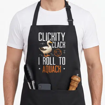 Playing d20 gaming apron - Duck and orange twenty-sided die between white and orange text reading CLICKITY CLACK I ROLL — shown on a black cotton canvas apron against a white background