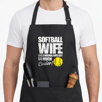 Fastpitch wife apron - White distressed text SOFTBALL WIFE with yellow softball and red stitching to right — shown on a black cotton canvas apron against a white background