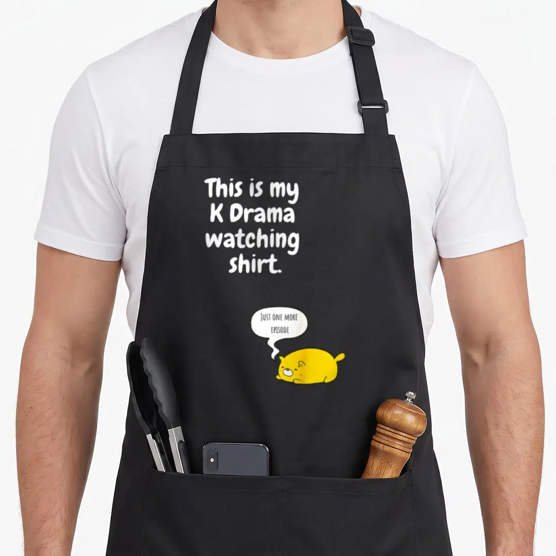 Army korean apron - Stacked white text and yellow cartoon cat with speech bubble requesting another episode — shown on a black cotton canvas apron against a white background