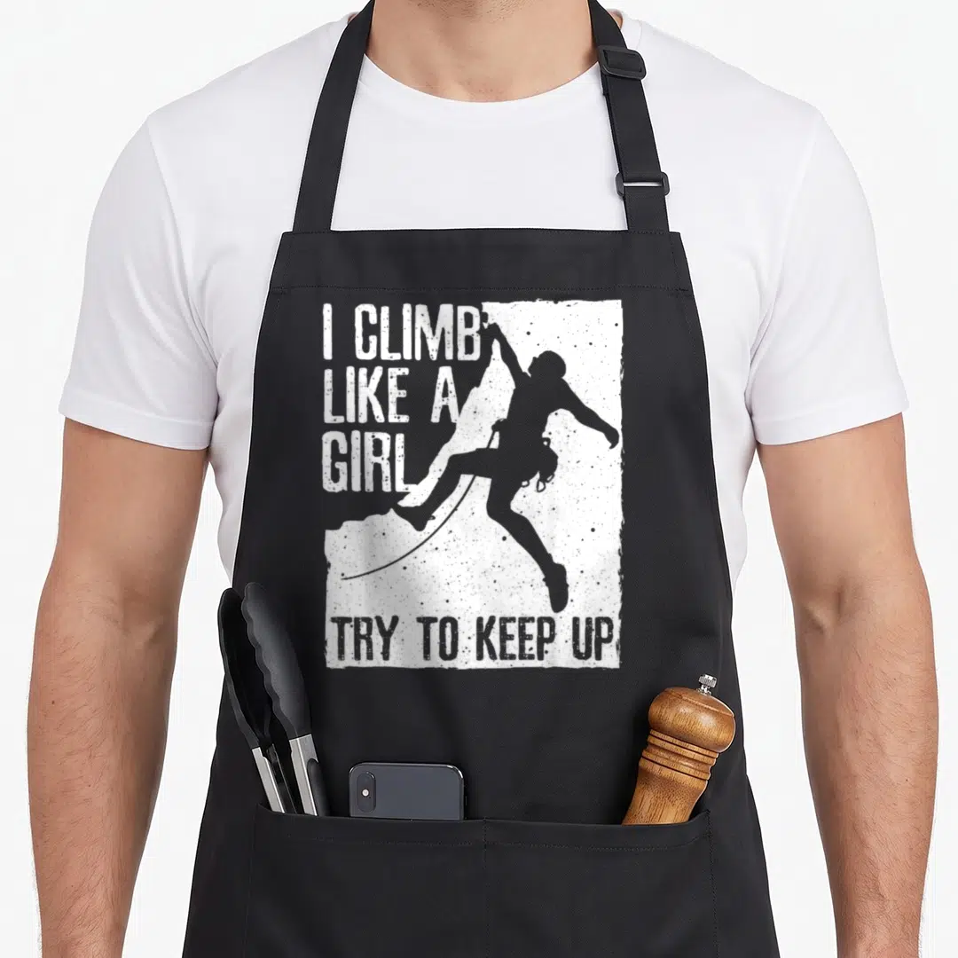 Rock climbing bouldering apron - I CLIMB LIKE A GIRL TRY TO KEEP UP text with grey climber silhouette on white — shown on a black cotton canvas apron against a white background