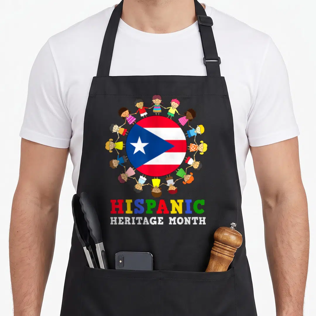 Puerto rican hispanic aprons - Cartoon children holding hands around a circular flag with colorful text below — shown on a black cotton canvas apron against a white background