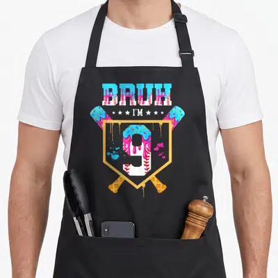 Baseball drip 9th ice cream apron - BRUH I'M text with dripping blue icing, pink stars, and number 9 on crossed waffle — shown on a black cotton canvas apron against a white background