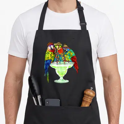 Parrot hawaiian apron - Three parrots in hats and sunglasses drinking from a large green cocktail glass with striped — shown on a black cotton canvas apron against a white background