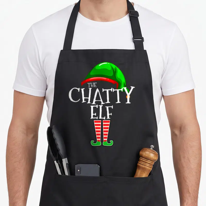Chatty elf apron - Green hat and striped legs formed by white text THE CHATTY ELF — shown on a black cotton canvas apron against a white background