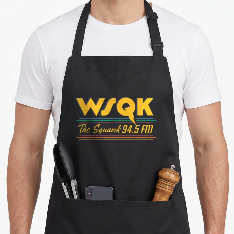 Season stranger apron - WSQK logo with lightning bolt and colored horizontal lines reading The Squawk 94.5 FM — shown on a black cotton canvas apron against a white background