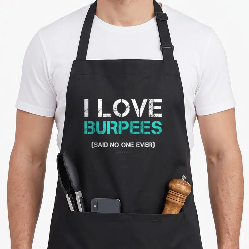 Funny gym burpees apron - I LOVE BURPEES SAID NO ONE EVER text in white and turquoise stacked typography — shown on a black cotton canvas apron against a white background