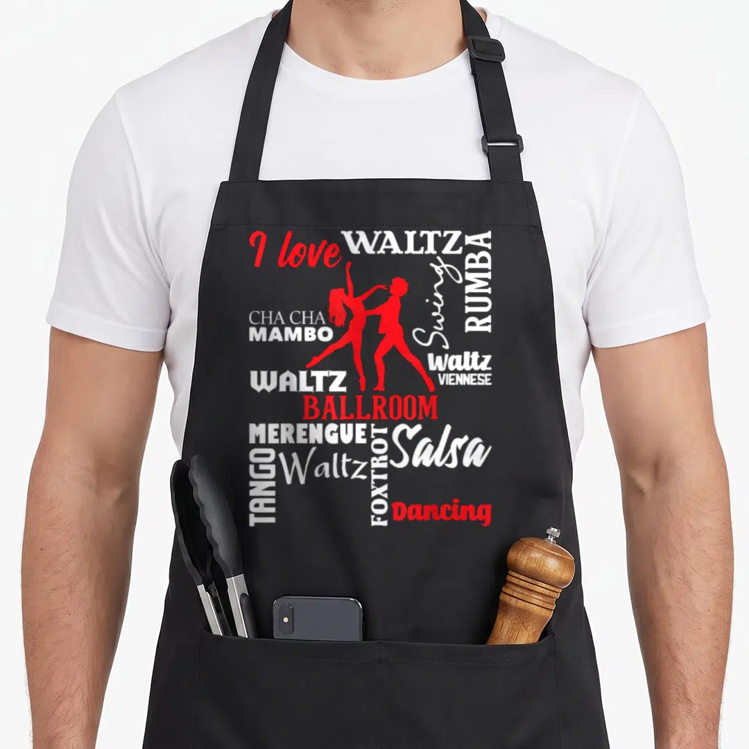 Instructor ballroom apron - Red dancer silhouettes surrounded by white and red text listing dance styles like Waltz — shown on a black cotton canvas apron against a white background