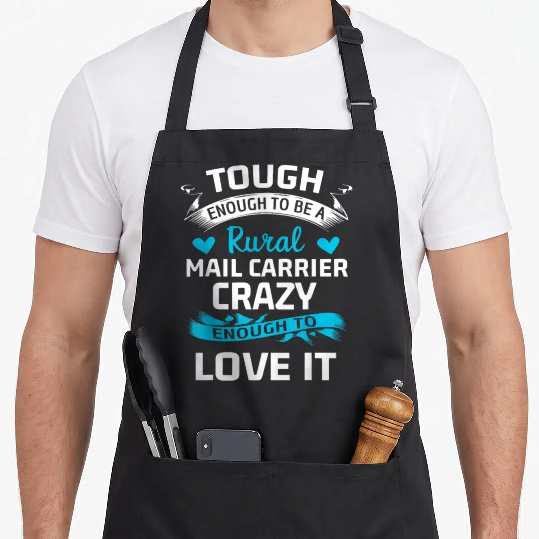 Mail letter carrier apron - White and blue stacked text with ribbons and two hearts reading Tough Enough Rural Mail — shown on a black cotton canvas apron against a white background