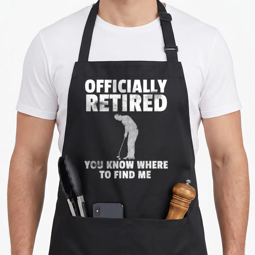 Retired golf apron - White distressed text Officially Retired with golfer silhouette putting — shown on a black cotton canvas apron against a white background