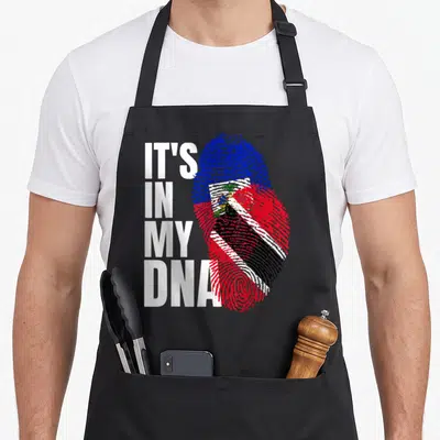 Mix dna heritage aprons - Stacked IT'S IN MY DNA text beside a blue red white and black fingerprint — shown on a black cotton canvas apron against a white background