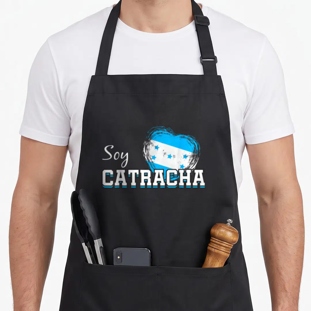 Soy honduran boy apron - Heart with Honduran flag and Soy CATRACHA text in blue white black — shown on a black cotton canvas apron against a white background