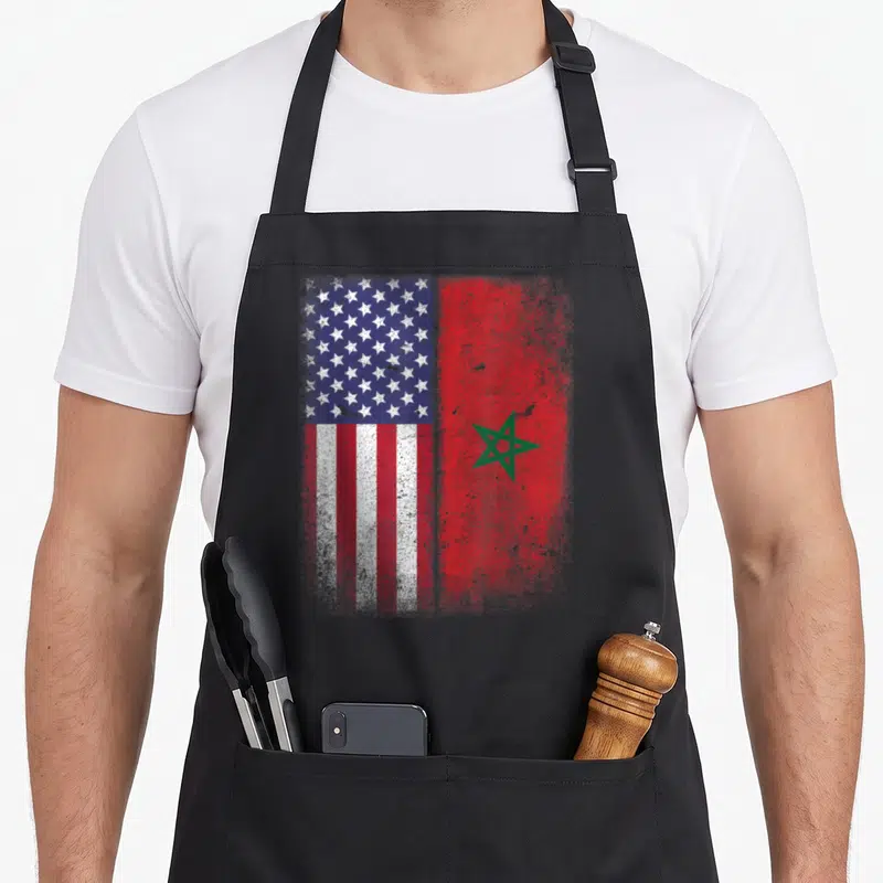 Funny morocco american flag apron - Distressed split American and Moroccan flags in red white blue and green — shown on a black cotton canvas apron against a white background