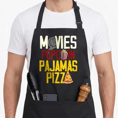 Snack pizza apron - Stacked MOVIES POPCORN PAJAMAS PIZZA text with reel, bucket, and slice icons in distressed style — shown on a black cotton canvas apron against a white background