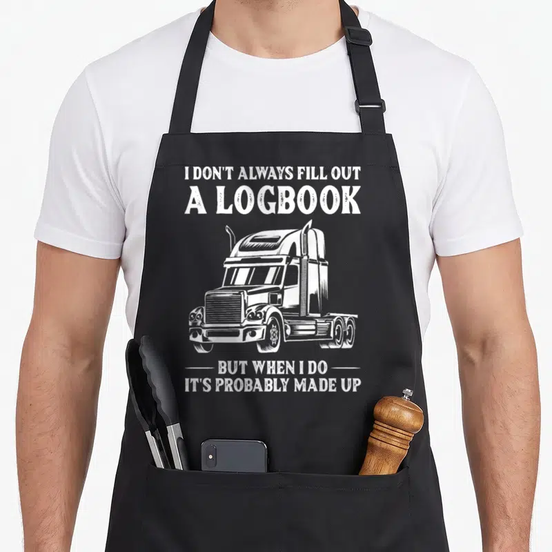 Driver rig truck apron - White distressed semi-truck with logbook sarcasm text — shown on a black cotton canvas apron against a white background