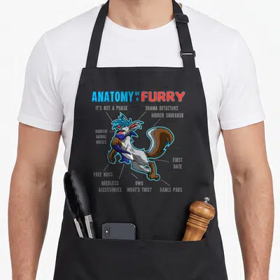 Cartoon anatomy apron - Furry character diagram with labels ANATOMY OF A FURRY, DRAMA MA PRACTORS, and HIDDEN SQUEAKER — shown on a black cotton canvas apron against a white background