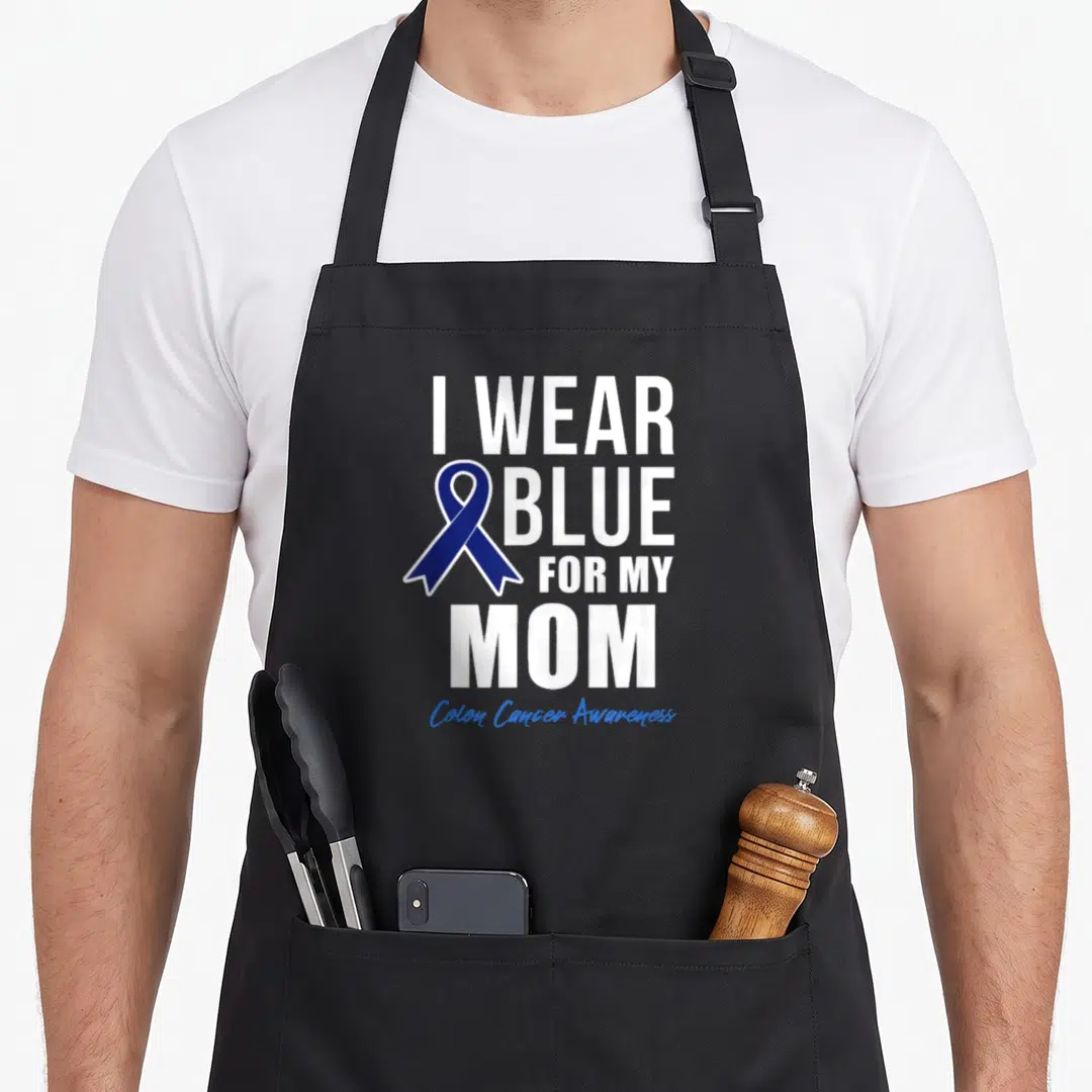 Colon crab dad apron - I WEAR BLUE FOR MY MOM text with dark blue ribbon and Colon Cancer Awareness script — shown on a black cotton canvas apron against a white background