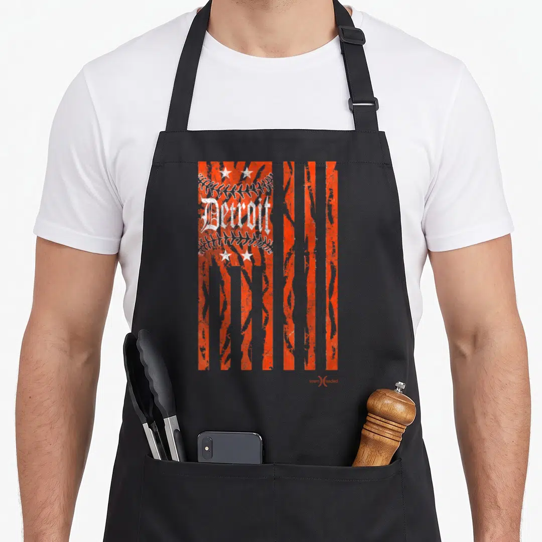 Baseball detroit apron - Distressed Detroit text over orange stripes with white baseball stitching and four stars — shown on a black cotton canvas apron against a white background