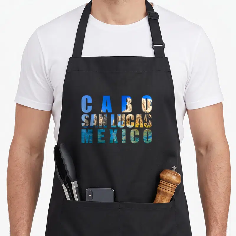 Arch mexico apron - Cabo San Lucas Mexico text filled with rock and ocean landscape photo — shown on a black cotton canvas apron against a white background