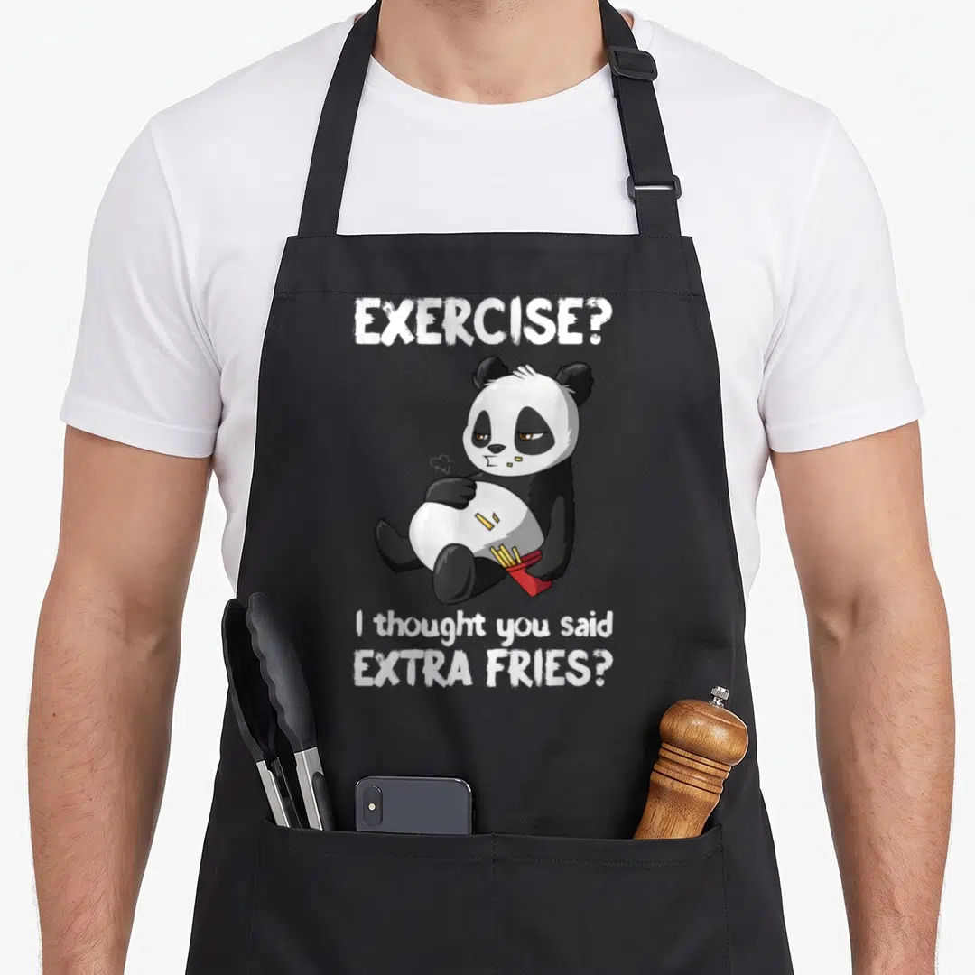 Panda exercise an extra apron - Cartoon panda holding red fry container with white text reading EXERCISE? EXTRA FRIES? — shown on a black cotton canvas apron against a white background