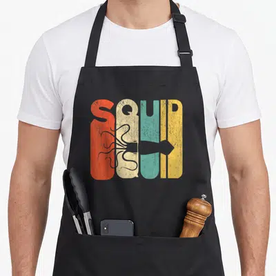 Silhouette squid mom apron - Retro SQUID text in red beige teal yellow with grey squid silhouette across center — shown on a black cotton canvas apron against a white background