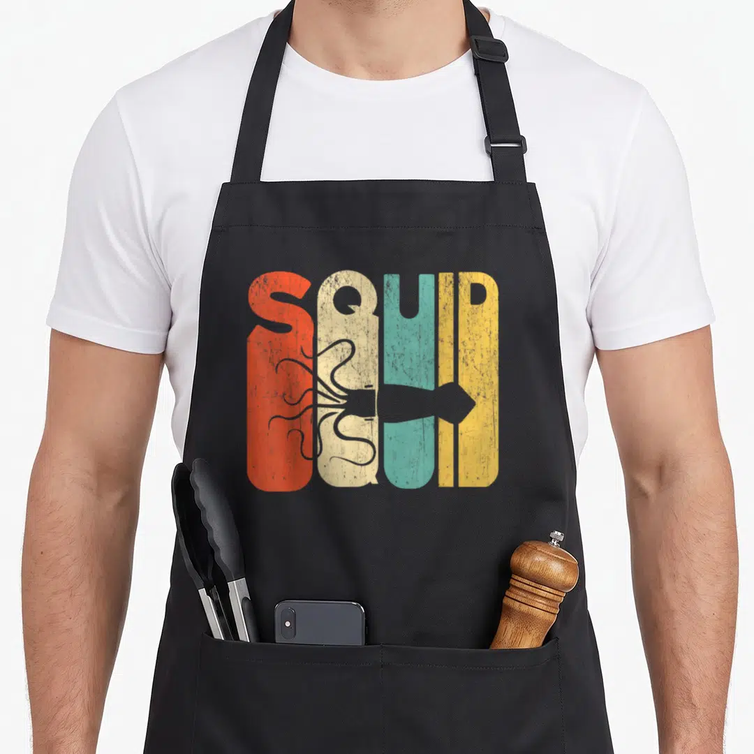Silhouette squid mom apron - Retro SQUID text in red beige teal yellow with grey squid silhouette across center — shown on a black cotton canvas apron against a white background