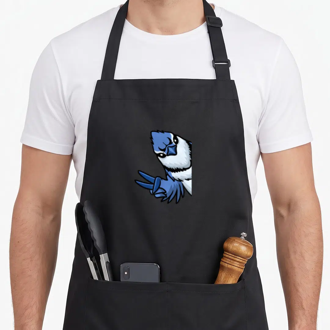 Cyanocitta bird apron - Cartoon blue jay peeking from right side in blue white and black ink — shown on a black cotton canvas apron against a white background