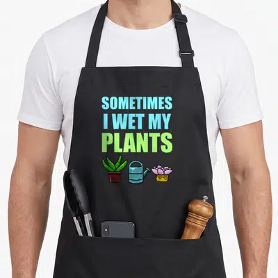 Sometime joke apron - Stacked blue and lime text reading Sometimes I Wet My Plants above cartoon aloe, watering can — shown on a black cotton canvas apron against a white background