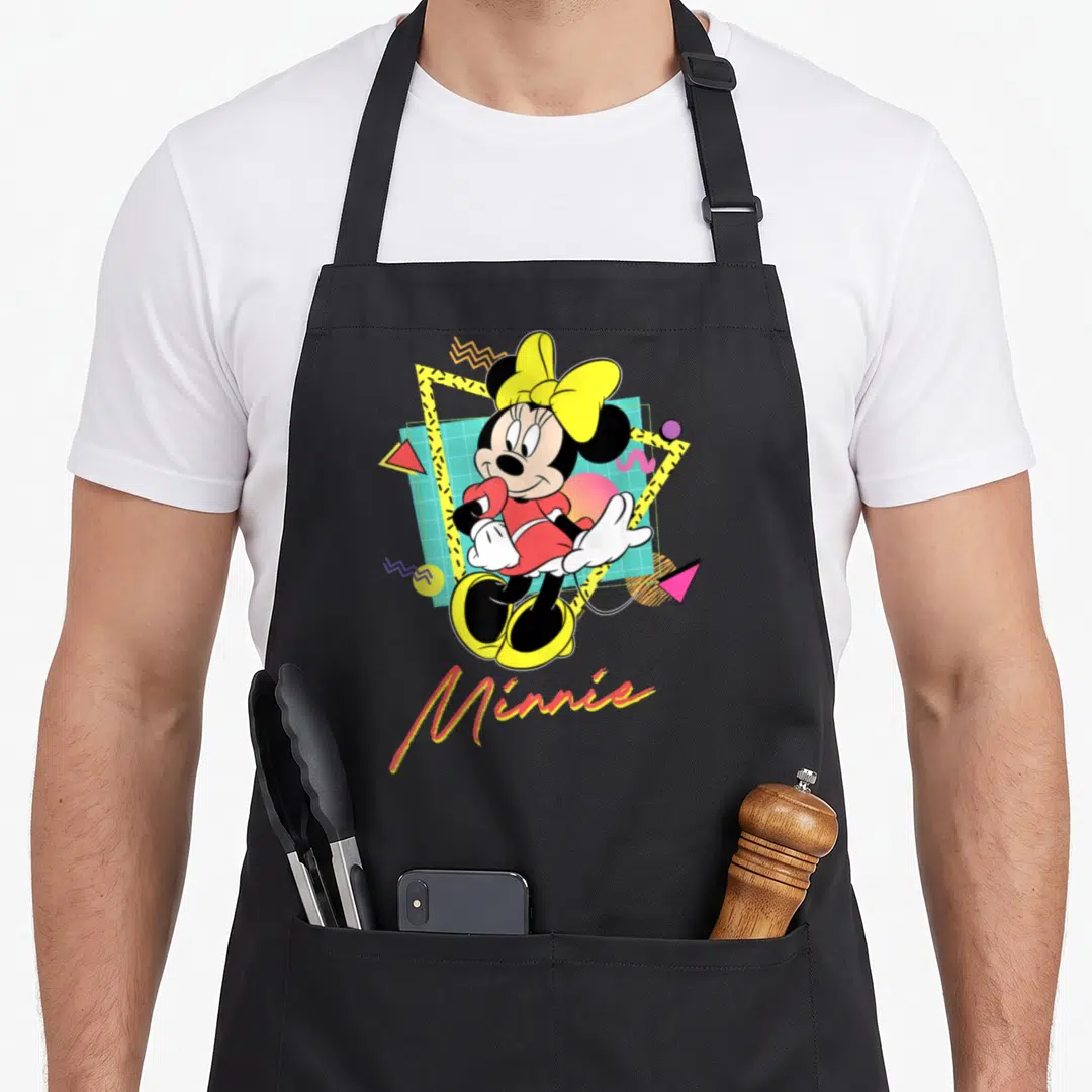 90s couple apron - Cartoon Minnie Mouse over cyan grid with yellow bow and geometric shapes — shown on a black cotton canvas apron against a white background