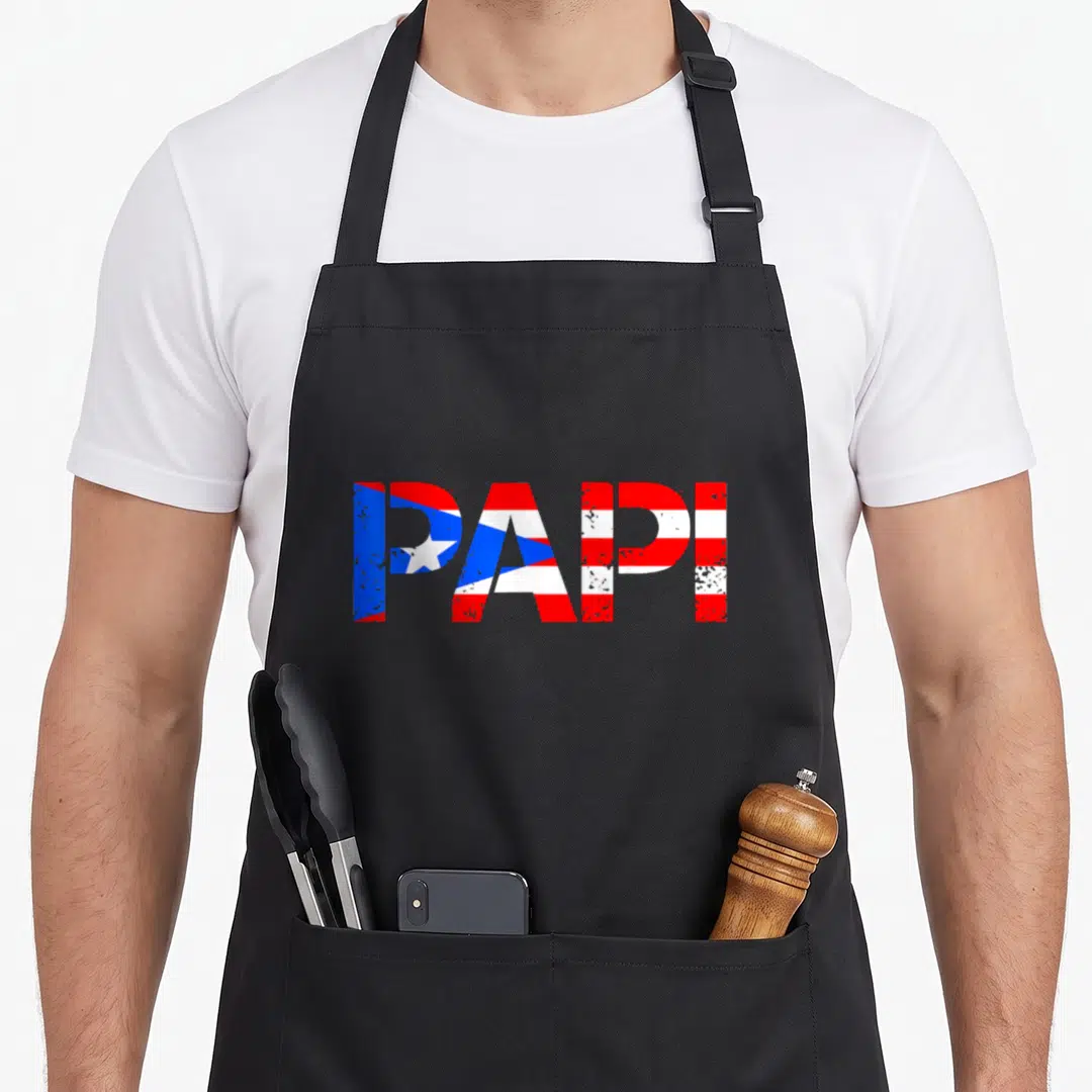 Puerto father day apron - PAPI text filled with red white and blue flag pattern and distressed texture — shown on a black cotton canvas apron against a white background