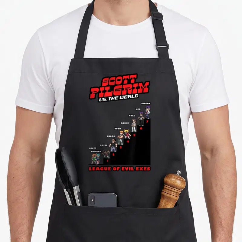 Scott pilgrim apron - Pixel art of 7 characters on black stairs with Scott Pilgrim title and League of Evil Exes text — shown on a black cotton canvas apron against a white background