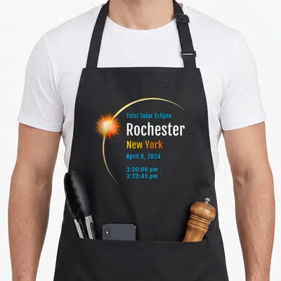 Total new york apron - Realistic glowing sun with Total Solar Eclipse Rochester NY text and 3:20:06 pm to 3:23:45 pm — shown on a black cotton canvas apron against a white background
