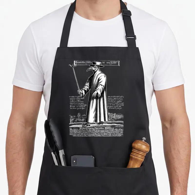 Funny plague doctor apron - Black and white 1656 plague doctor woodcut with German text columns and landscape border — shown on a black cotton canvas apron against a white background