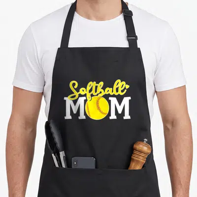 Softball mother's apron - Yellow script Softball MOM with red stitched ball replacing O and small heart accent — shown on a black cotton canvas apron against a white background