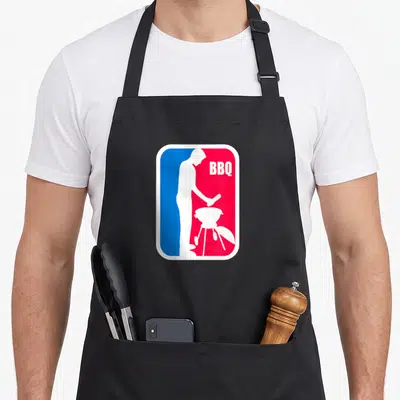 League barbecue apron - White man grilling silhouette on split blue red background with BBQ text — shown on a black cotton canvas apron against a white background