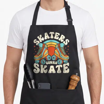 Skater skate 70s apron - Retro blue and orange roller skates with red stars and arching SKATERS GONNA SKATE text — shown on a black cotton canvas apron against a white background