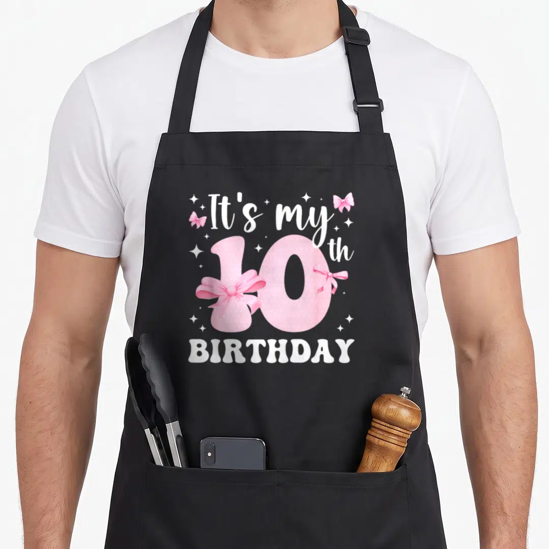 Themed bow apron - Pink number 10 with bows and It's my 10 th BIRTHDAY text — shown on a black cotton canvas apron against a white background