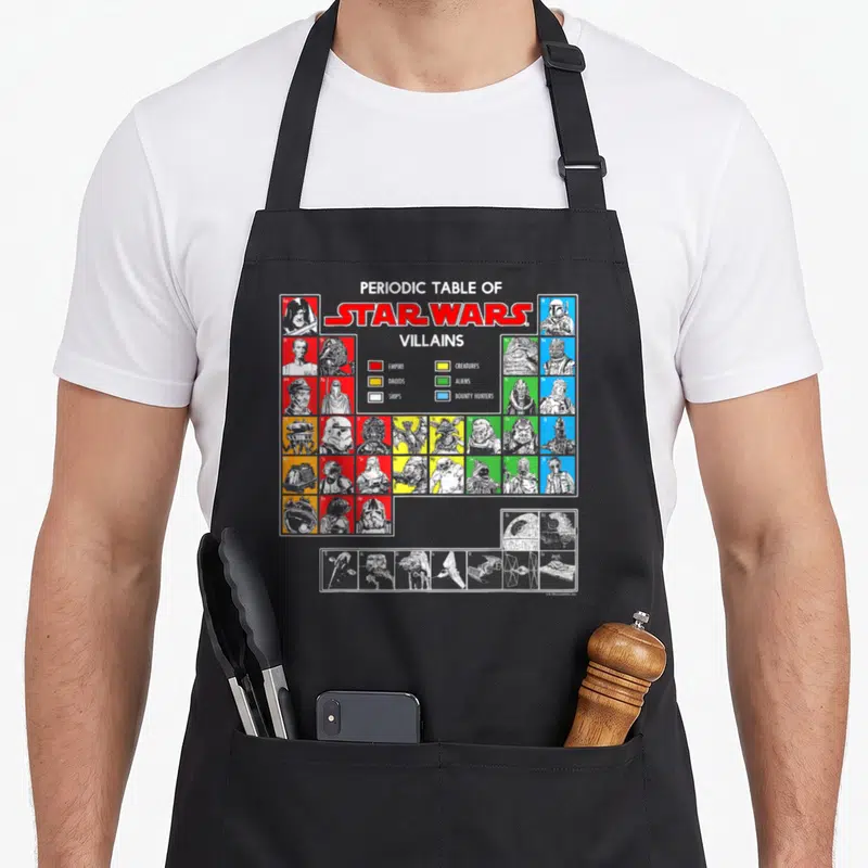 Vintage periodic table apron - Star Wars villains grid with colored squares for empire, droids, creatures, aliens — shown on a black cotton canvas apron against a white background