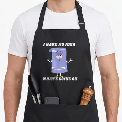 Towelie cartoon apron - Purple towel character holding can and cigarette between white text lines — shown on a black cotton canvas apron against a white background