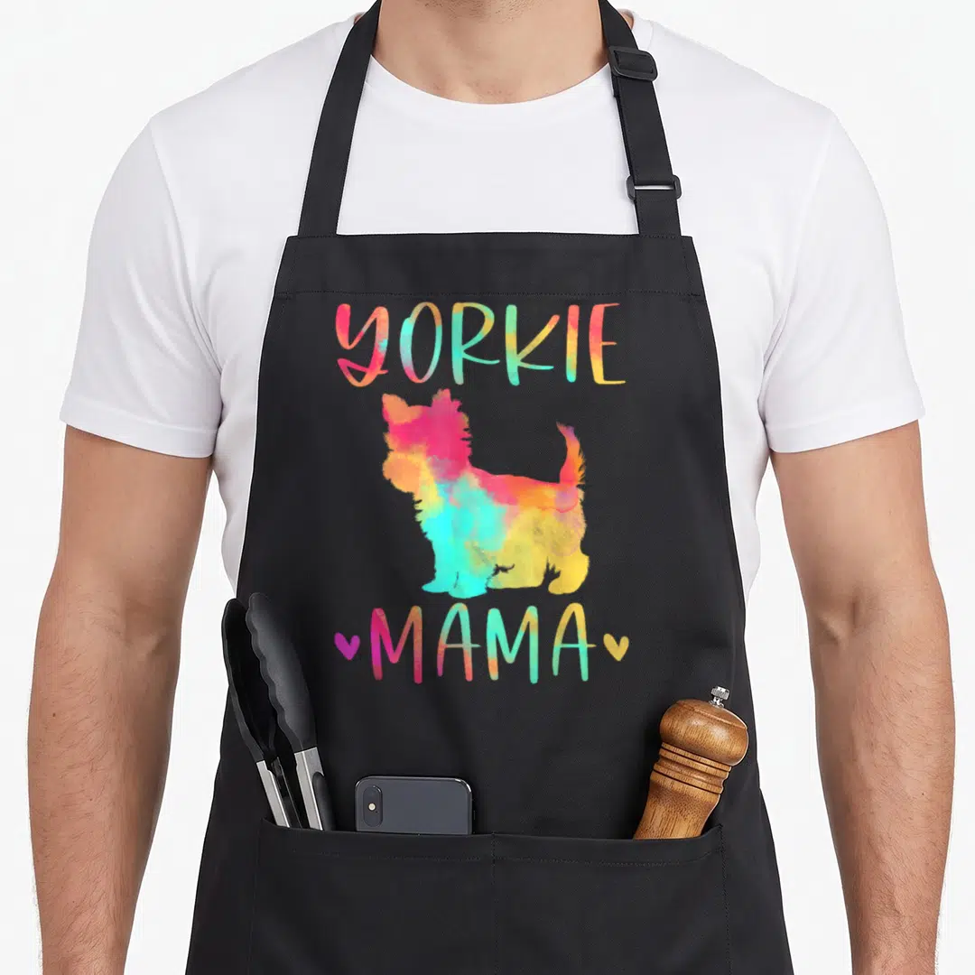 Mama colorful yorkie apron - Rainbow watercolor Yorkshire Terrier silhouette with YORKIE MAMA text and two hearts — shown on a black cotton canvas apron against a white background